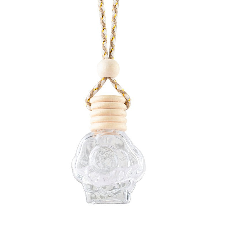Clear rose-shaped car diffuser bottle with ribbed wooden cap and hanging cord