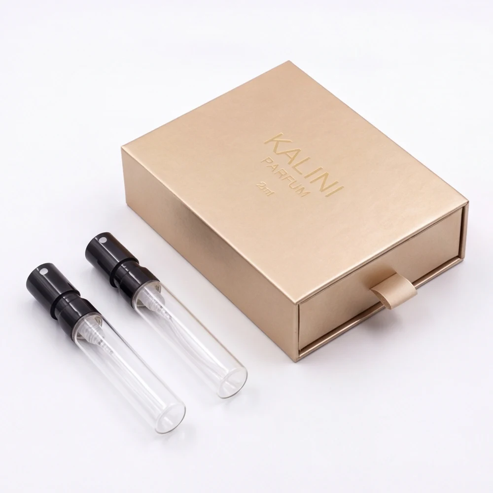 Two perfume sample vials with a gold drawer presentation box