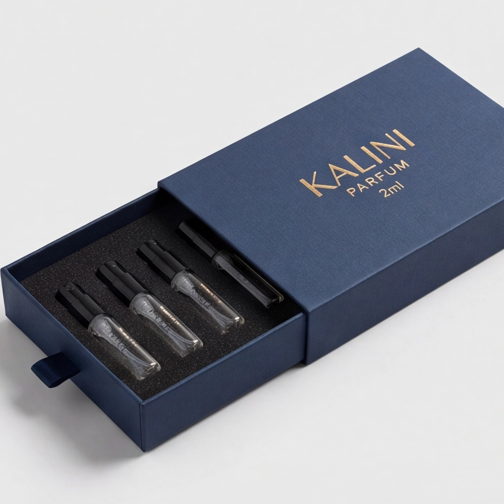 Four perfume sample vials in an open blue drawer packaging box